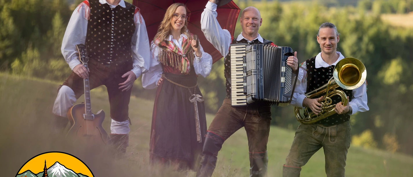 Vier Musiker der Geininger in Tracht mit Gitarre, Akkordeon und Tuba vor grüner Landschaft