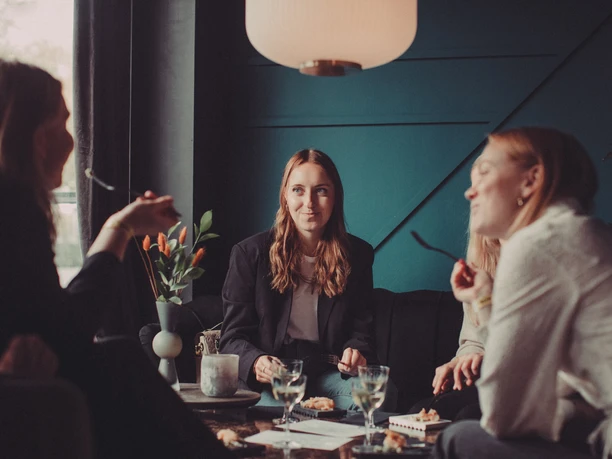 Three women are enjoying appetizers and drinks at a bar in Cologne on Moveat