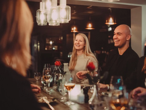 Smiling guests at a Moveat evening of indulgence with wine and candlelight in Cologne