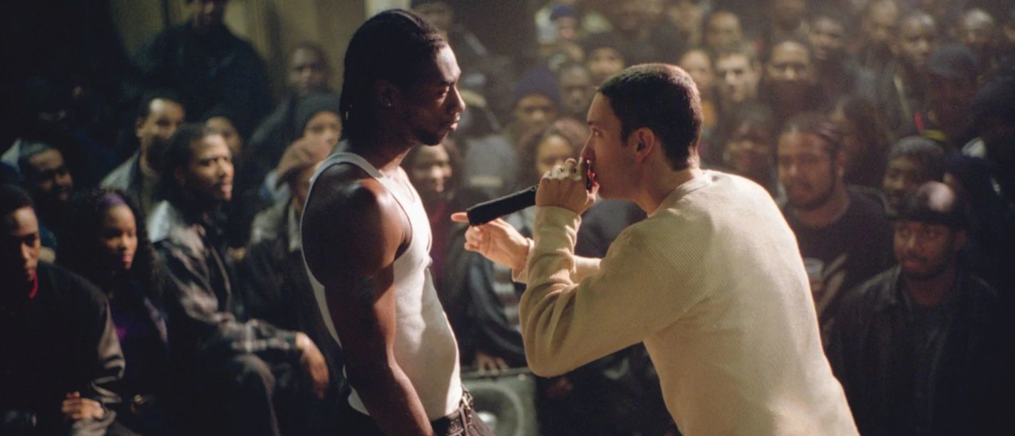 Rapper mit Mikrofon im Duell vor dicht gedrängtem Publikum bei CinemaSings zu „8 Mile“