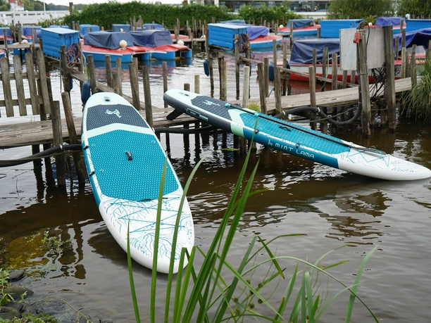 Zwei SUP-Boards liegen am Anleger der Bootsvermietung am Zwischenahner Meer.