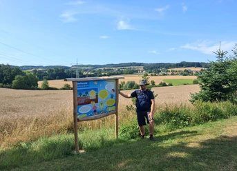 Mann an Informationstafel zur Geothermie am Energie-Entdecker-Pfad Bentorf.
