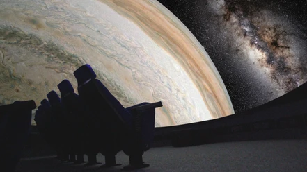 Innenkuppel des Planetariums mit Bestuhlung. Projektion eines Planeten und des Weltalls.