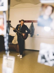 DSCF6895.jpg Thees Uhlmann mit Gitarre in einer Garderobe.