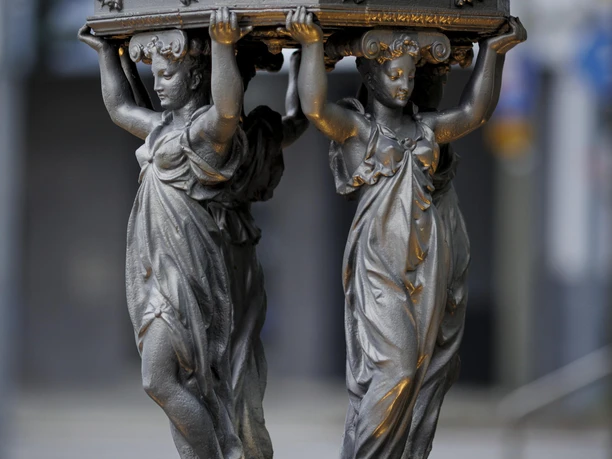 Detail des Wallace-Brunnens in Burscheid mit zwei tragenden Frauenfiguren aus Metall