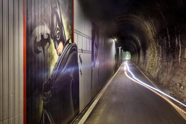 Beleuchteter Fledermaustunnel in Hückeswagen mit Batman-Graffiti und Lichtspuren