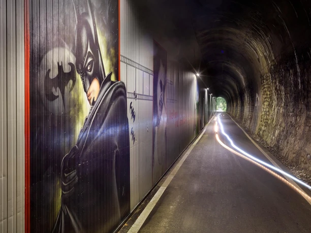 Beleuchteter Fledermaustunnel in Hückeswagen mit Batman-Graffiti und Lichtspuren