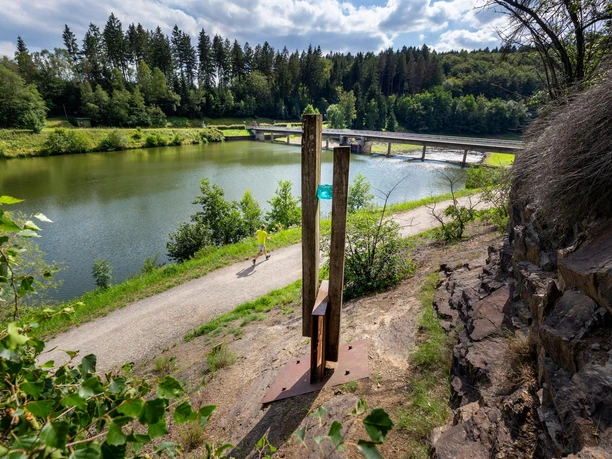 Holzskulptur „Licht“ am Ufer der Wuppertalsperre mit Wald, Weg und Brücke
