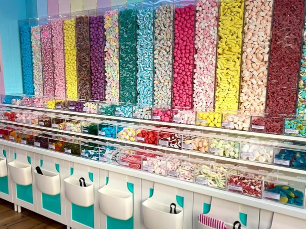 Bunte Süßigkeiten zum Selbstmischen in transparenten Behältern im Laden.