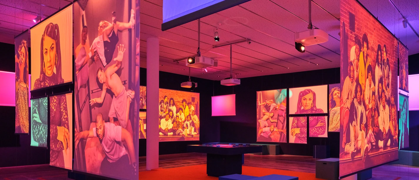 Ausstellungsraum im Jüdischen Museum Frankfurt mit großformatigen Porträts in farbigem Licht
