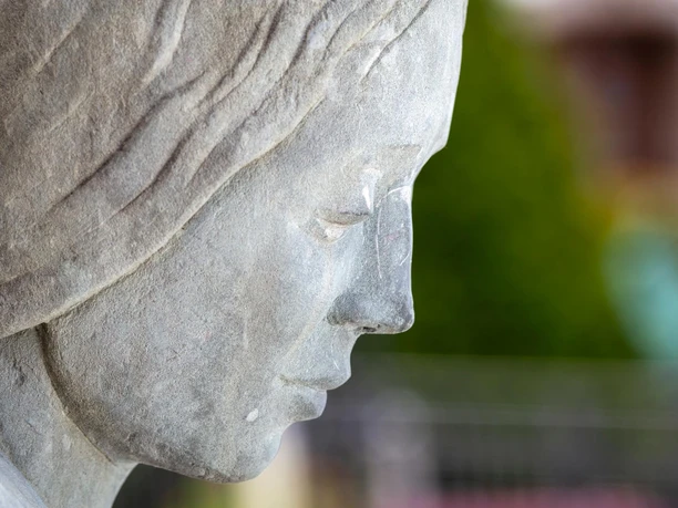 Nahaufnahme der Steinskulptur „Frau am Brunnen“ in Wipperfürth, Profil mit feinen Zügen