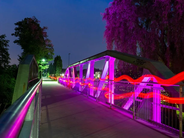 Bogenbrücke in Wipperfürth bei Nacht mit pink-roter Lichtinszenierung über der Wupper