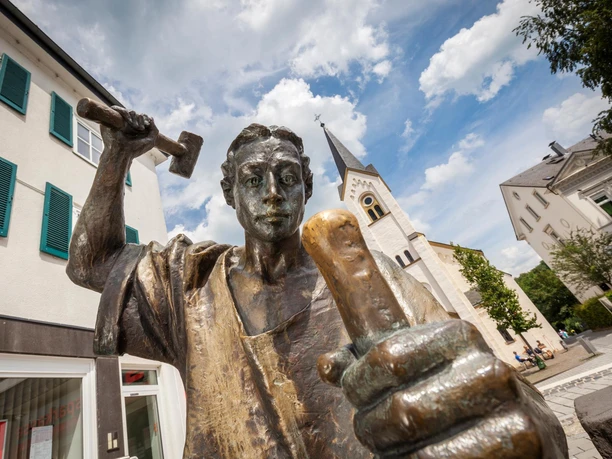 Bronzefigur Der Münzschläger mit Hammer vor Kirche in Wipperfürth