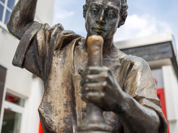 Bronzeskulptur „Der Münzschläger“ mit erhobenem Hammer in Wipperfürth