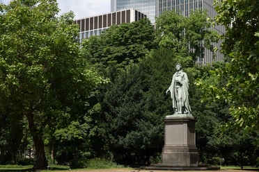 Frankfurt - Schiller Monument Schiller Monument in the Taunusanlage, surrounded by trees and Frankfurt's high-rises