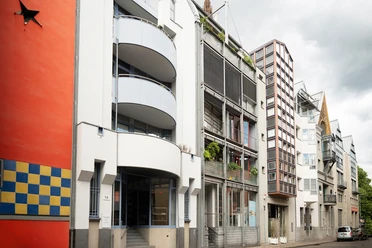 Building facades with balconies on Frankfurt's Saalgasse under a cloudy sky