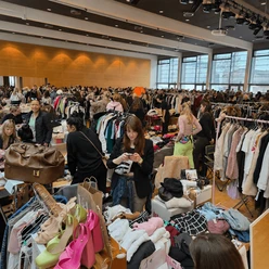 A bustling fashion flea market in Cologne featuring clothing, shoes, and many visitors