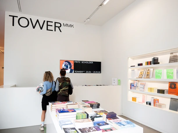 Eingangsbereich des TOWER MMK mit Museumsshop und zwei Besuchenden