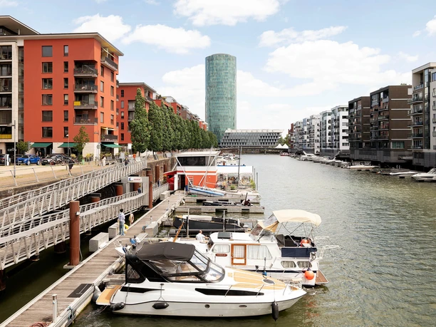 Boote am Steg vor der Kombüse im Frankfurter Westhafen mit modernen Wohnhäusern