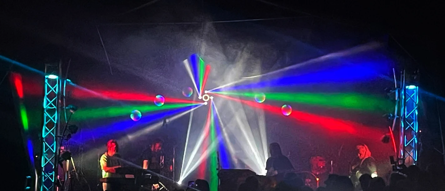 Psychedelic-Rock-Konzert mit bunten Laserstrahlen und Band auf dunkler Bühne