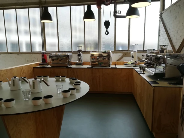 Rösterei-Schulungsraum mit Espressomaschinen, Kaffeetassen und Kannen
