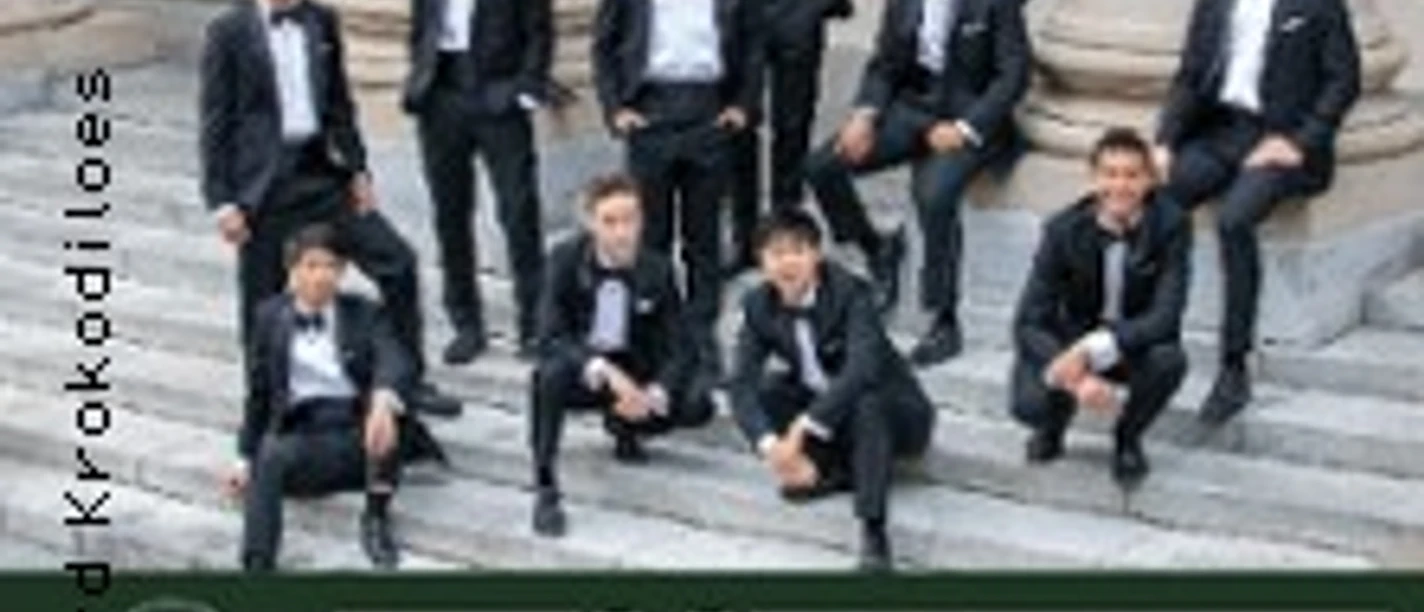 Gruppenfoto der Harvard Krokodiloes in Anzügen vor der Volksbühne Köln