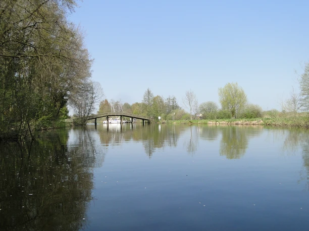 Hagenburger Kanal Der Hagenburger Kanal im Frühling, ruhiges Wasser, umgeben von Bäumen, mit einer Brücke im Hintergrund.