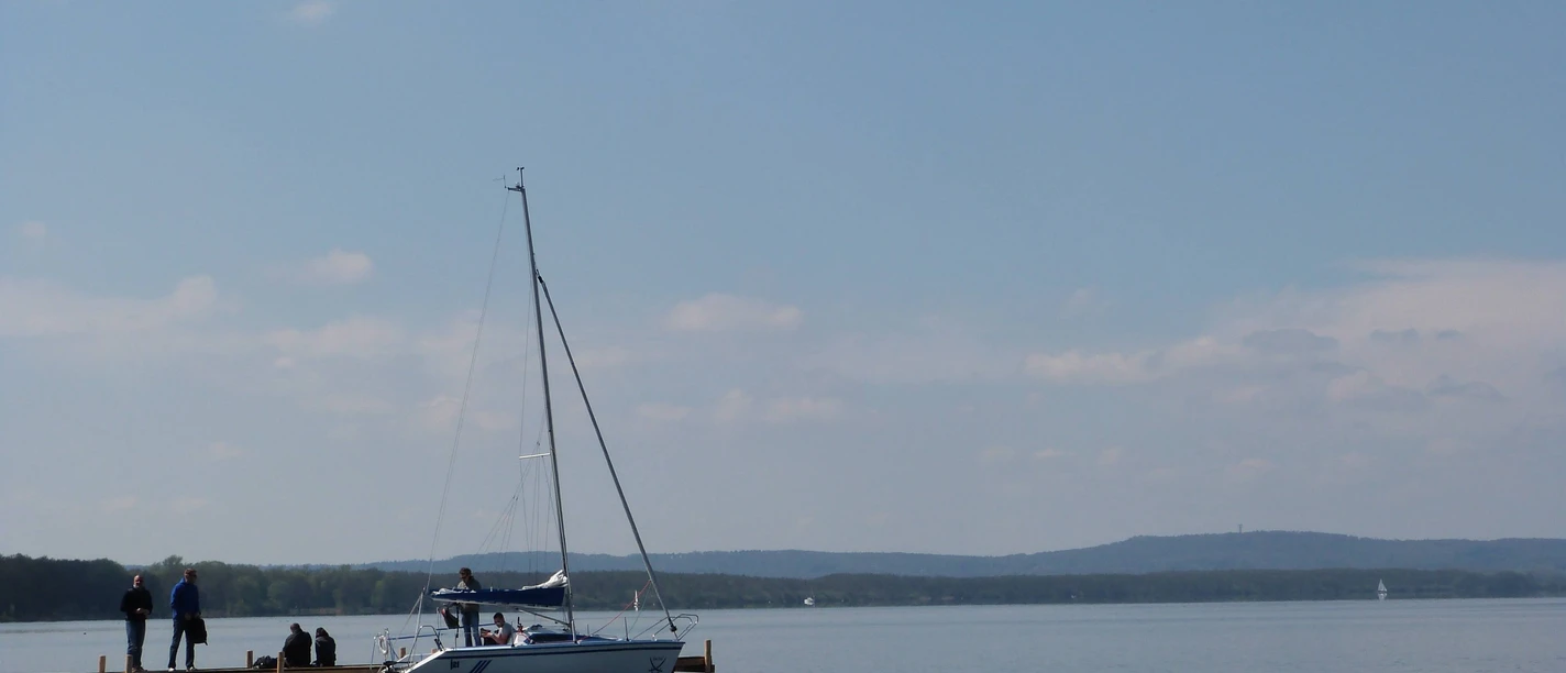 Segelboot Steinhuder Meer A sailing boat with a calm water surface on the shore of the Steinhuder Meer under a clear sky.