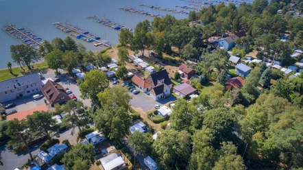 Uferweg Mardorf Luftaufnahme eines belebten Campingplatzes am Steinhuder Meer mit vielen Bootsanlegeplätzen und Grünflächen.