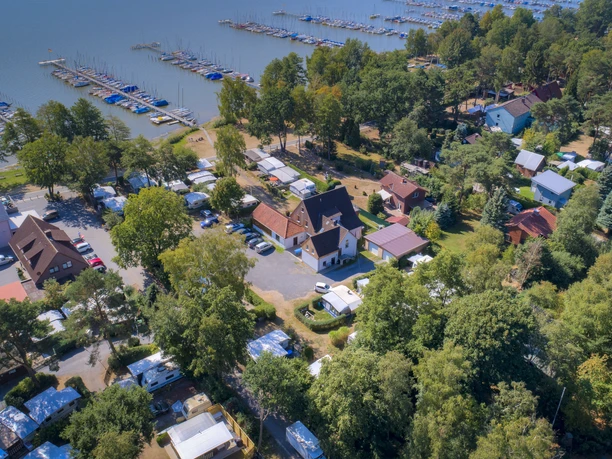Uferweg Mardorf Luftaufnahme eines belebten Campingplatzes am Steinhuder Meer mit vielen Bootsanlegeplätzen und Grünflächen.