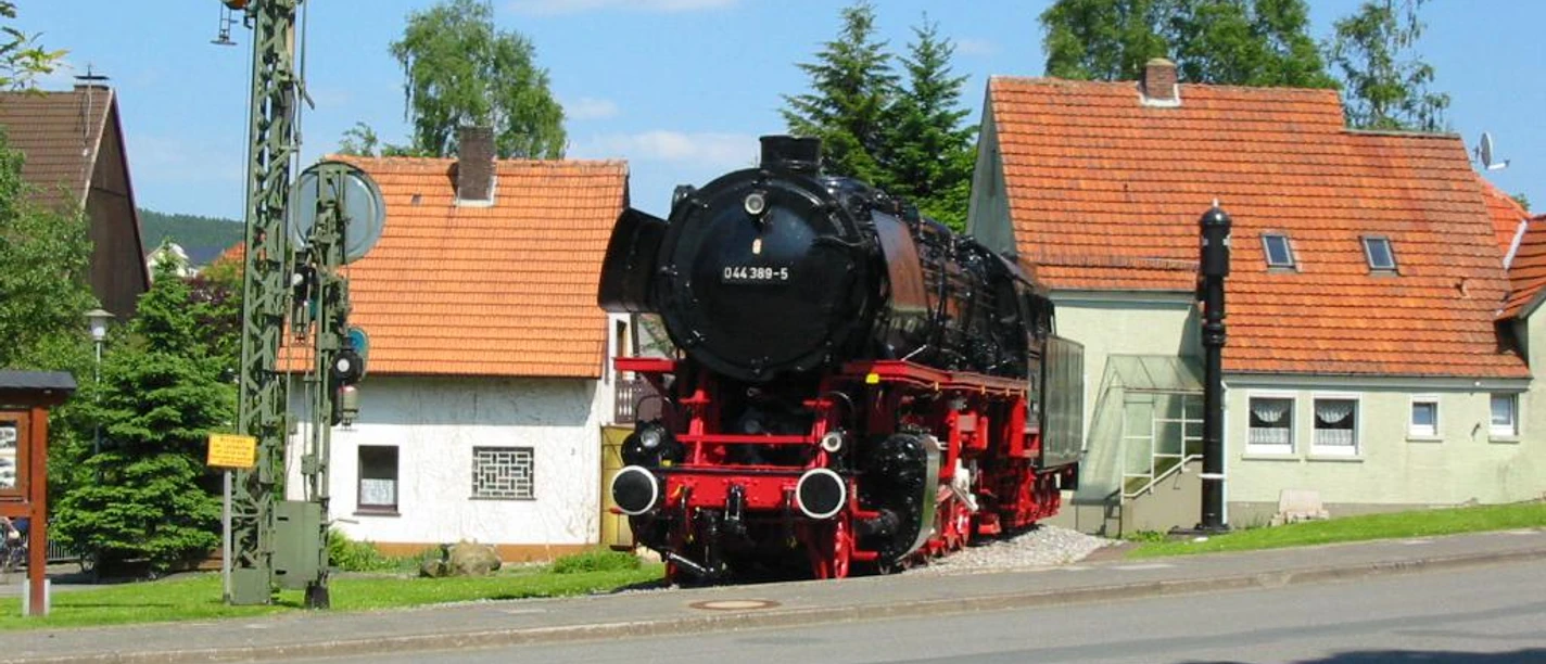 Denkmal-Lokomotive 044 in Altenbeken Historische Dampflok 044-389-5 steht auf Gleisstück vor Fachwerkhäusern in Altenbeken.