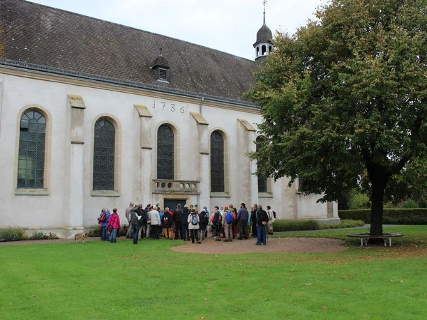 St. Vitus Pfarrkirche Eine Gruppe von Menschen versammelt sich vor einer historischen Kirche mit dem Baujahr 1736.