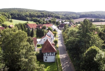 Heidelbeck von oben Luftaufnahme eines kleinen Dorfes mit Fachwerkhäusern, umgeben von Wäldern und Feldern in Heidelbeck.
