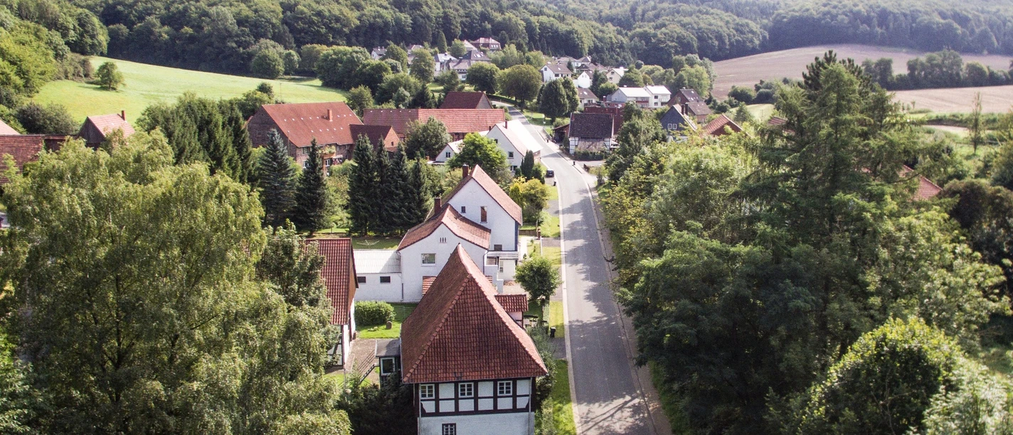 Heidelbeck von oben Luftaufnahme eines kleinen Dorfes mit Fachwerkhäusern, umgeben von Wäldern und Feldern in Heidelbeck.