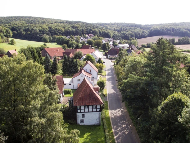 Heidelbeck von oben Luftaufnahme eines kleinen Dorfes mit Fachwerkhäusern, umgeben von Wäldern und Feldern in Heidelbeck.