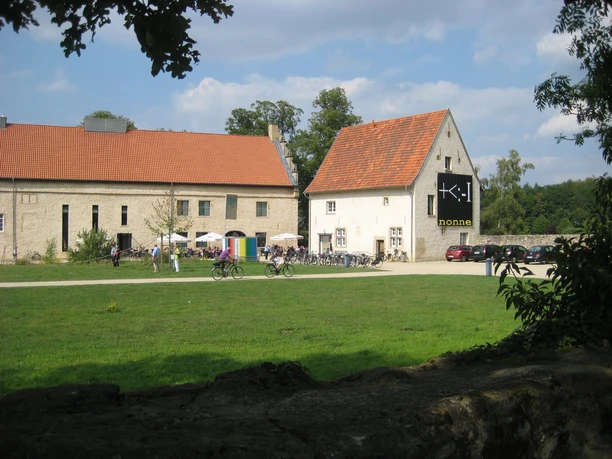 Kunsthaus Gravenhorst Blick auf das Kunsthaus Gravenhorst mit rotem Ziegeldach, hellem Außenanstrich und Besuchern im Freien.