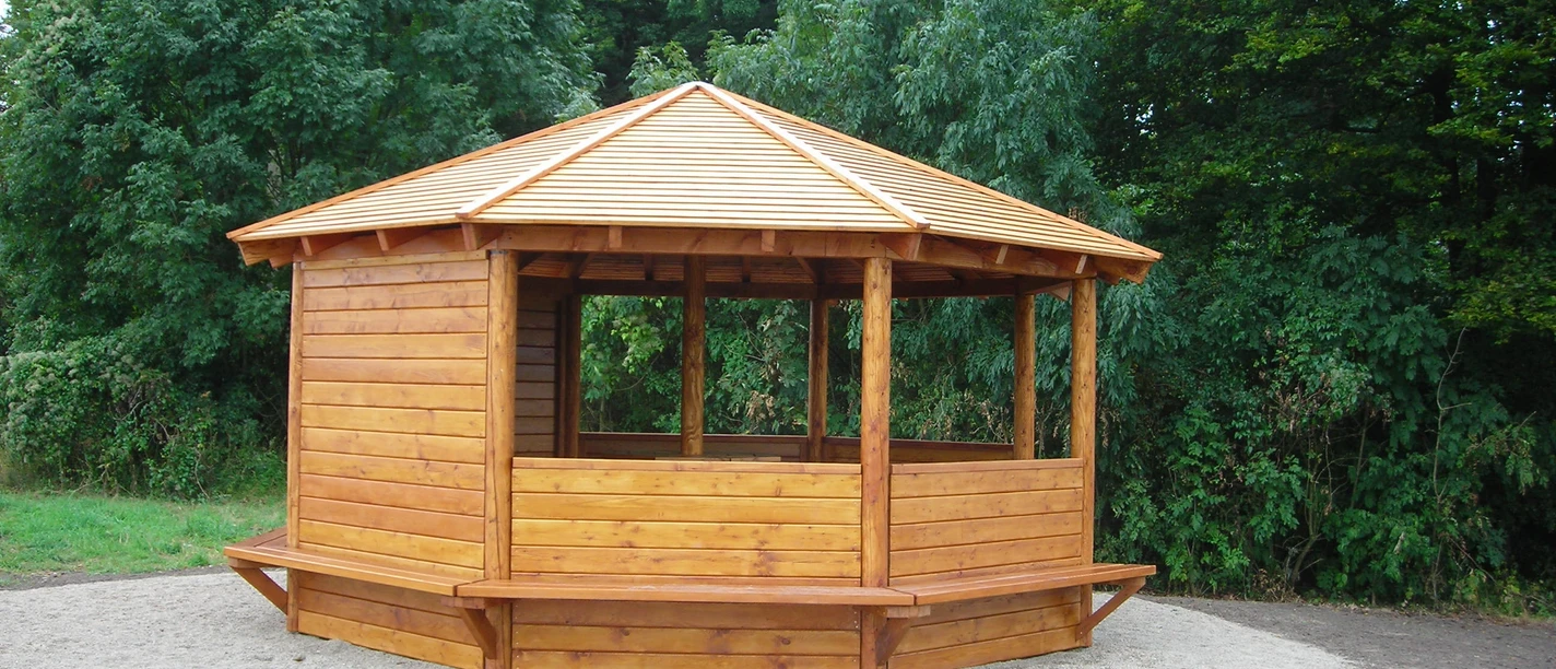 Schutzhütte Lengericher Berg Achteckige Holzschutzhütte auf geräumiger Lichtung, umgeben von dichtem Grün, mit Sitzgelegenheiten.