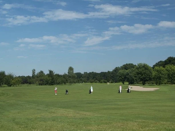 Golfplatz in Peckeloh Mehrere Golfspieler auf einem grünen Fairway eines Golfplatzes unter blauem Himmel mit Wolken.