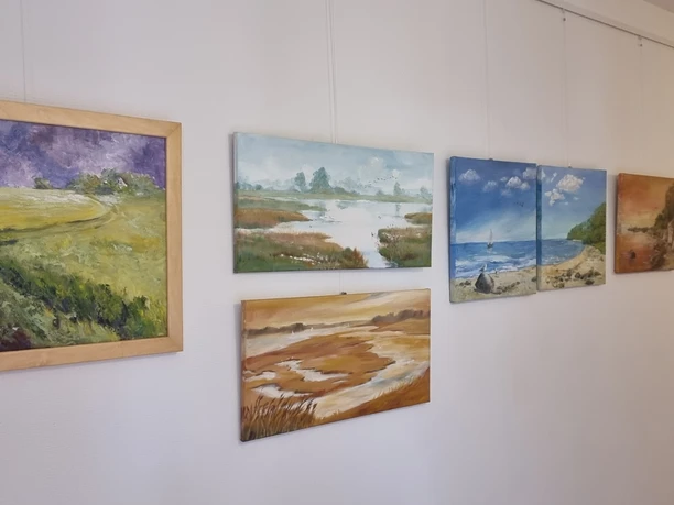 Galerie Gohrisch im Gemeindehaus Künstlerin Brigitta Arnold Fünf Landschaftsgemälde in verschiedenen Farben und Stilen an einer weißen Wand.
