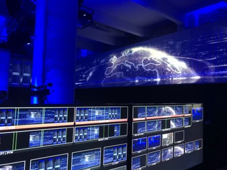 MedienReich - Control Room Control room with monitors and a blue projection of a globe.