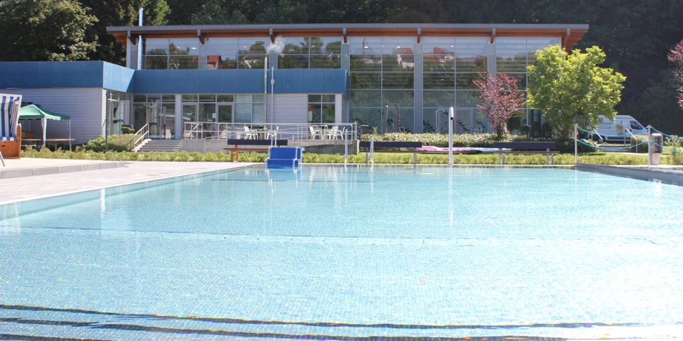 Waldschwimmbad Bad Wünnenberg Waldschwimmbad Bad Wünnenberg mit glitzerndem Wasser, umgeben von Bäumen und moderner Architektur.