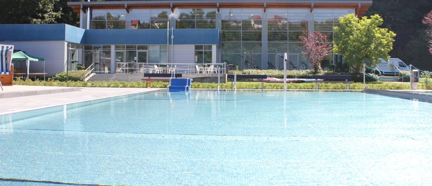 Waldschwimmbad Bad Wünnenberg Waldschwimmbad Bad Wünnenberg mit glitzerndem Wasser, umgeben von Bäumen und moderner Architektur.