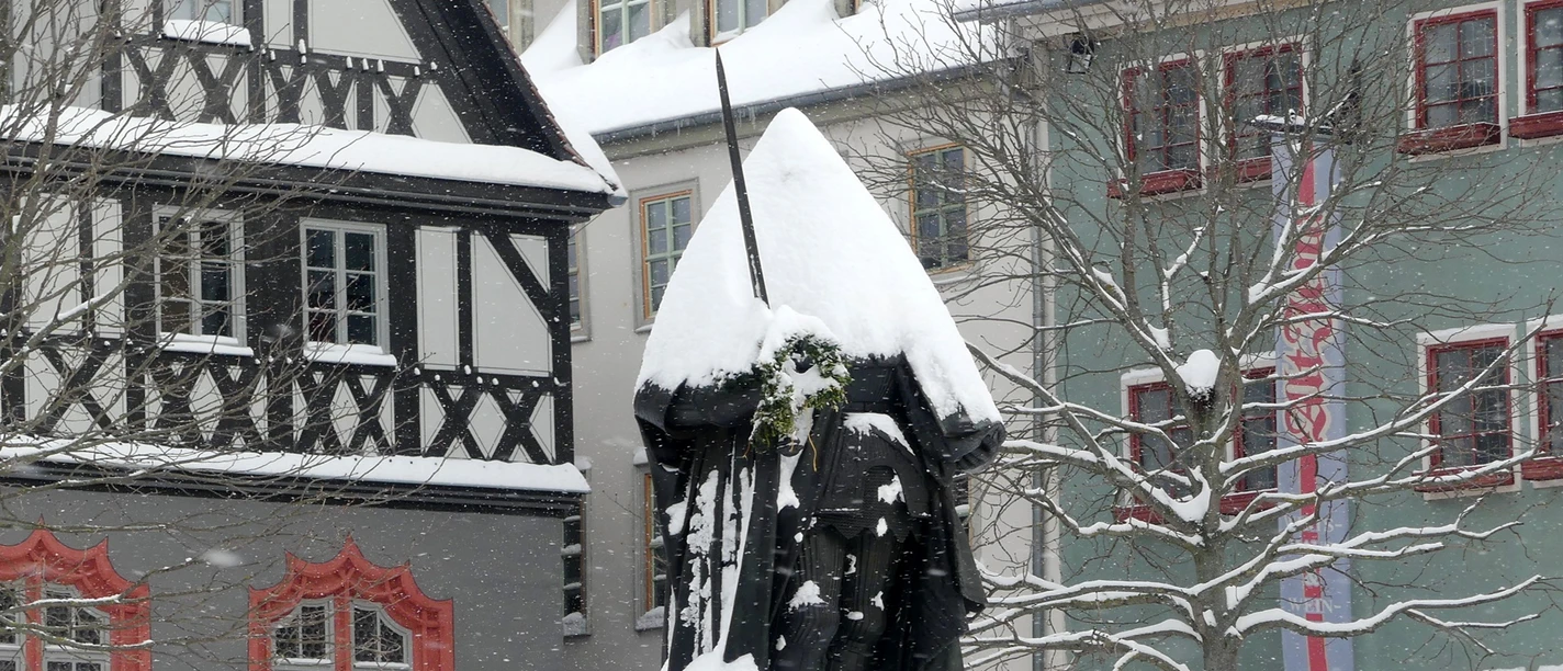 Mit Schnee bedeckte Hanfried-Statue auf dem Jenaer Marktplatz