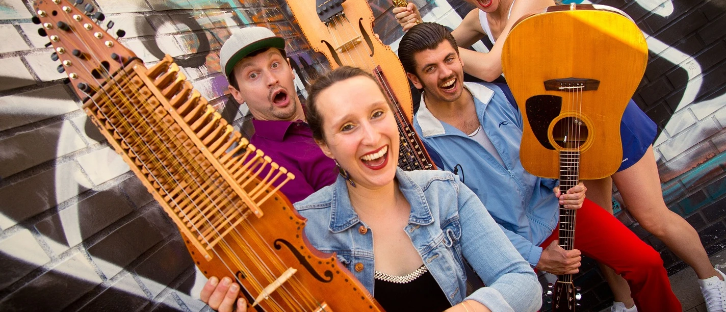 vier köpfige, junge flippige Band lacht mit ihren Instrumenten