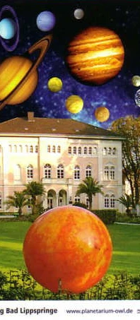 Ein großes, historisches Gebäude wird von einer fantasievollen Darstellung des Sonnensystems überragt.