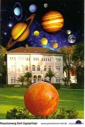 "Der Planetenweg" Bad Lippspringe Ein großes, historisches Gebäude wird von einer fantasievollen Darstellung des Sonnensystems überragt.