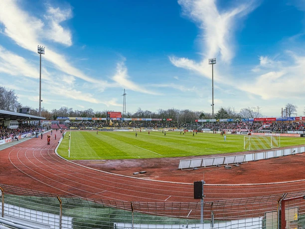Panoramablick ins Kölner Südstadion mit Spielfeld, Laufbahn und besetzten Tribünen