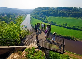 Aussichtsplattform Weser-Skywalk Eine Gruppe von Menschen steht auf einer Aussichtsplattform, die über das Tal der Weser ragt.