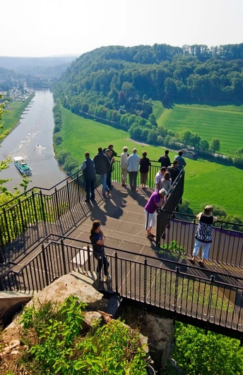 Aussichtsplattform Weser-Skywalk Eine Gruppe von Menschen steht auf einer Aussichtsplattform, die über das Tal der Weser ragt.