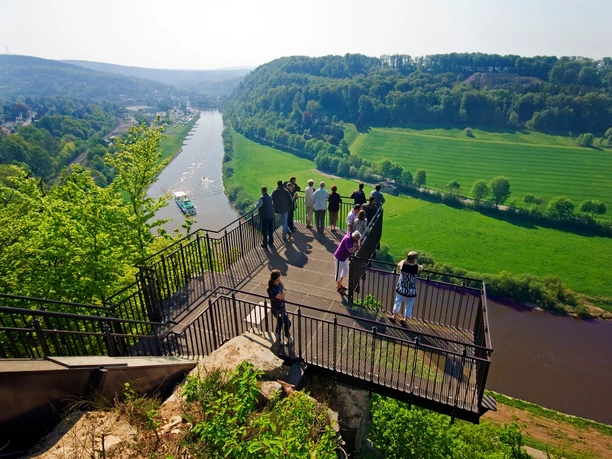Aussichtsplattform Weser-Skywalk Eine Gruppe von Menschen steht auf einer Aussichtsplattform, die über das Tal der Weser ragt.